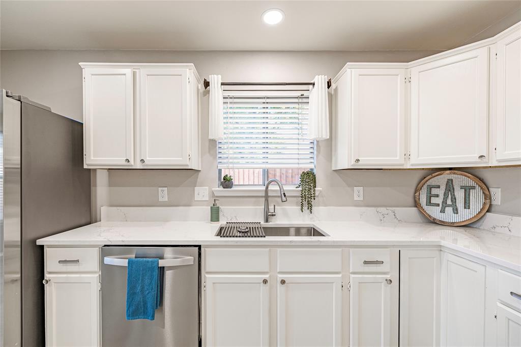 a kitchen with stainless steel appliances granite countertop a sink a refrigerator a window and cabinets