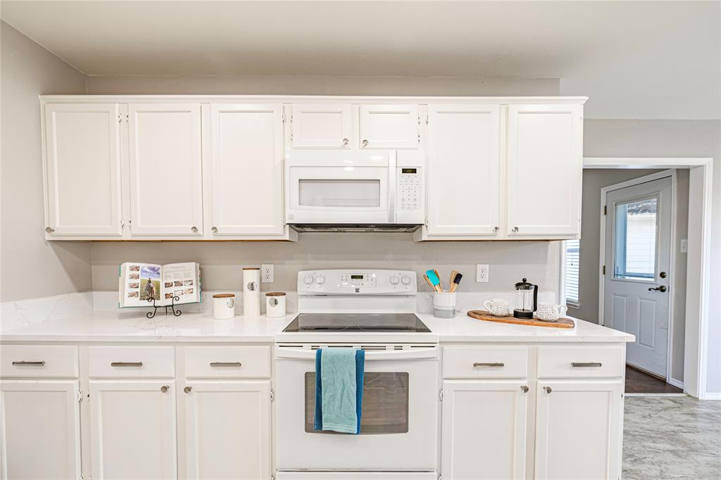 1805 Creek Crossing Garland, TX 75040 - Photo 14 of 39 a kitchen with white cabinets and white appliances