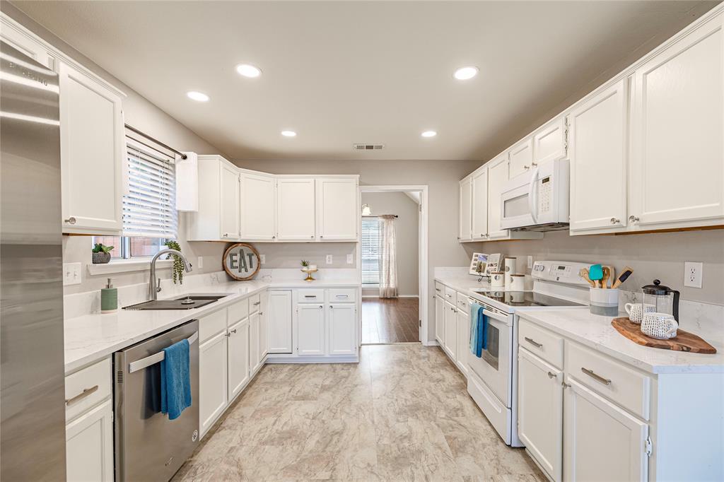 1805 Creek Crossing Garland, TX 75040 - Photo 15 of 39 a kitchen with white cabinets appliances and a sink