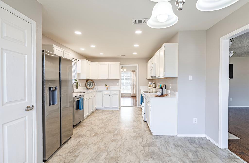 1805 Creek Crossing Garland, TX 75040 - Photo 16 of 39 a view of a kitchen with a sink and dishwasher a refrigerator with white cabinets