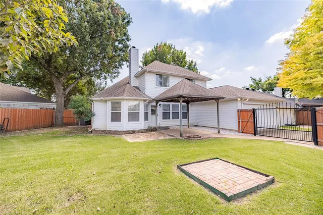 a view of a house with a yard and sitting area