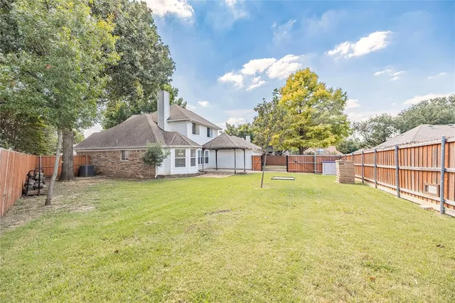 a house that has a big yard plants and large trees