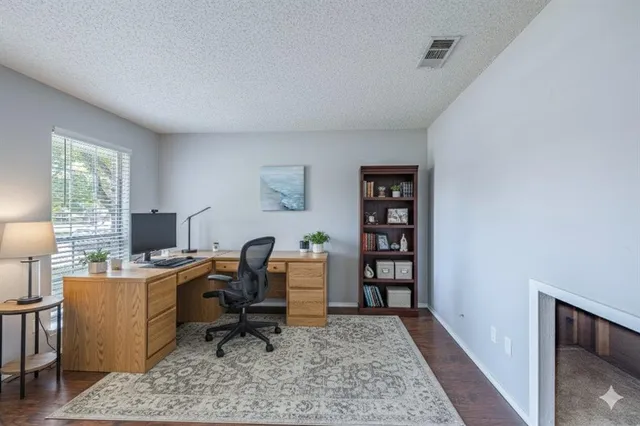 a view of a workspace with furniture and a window