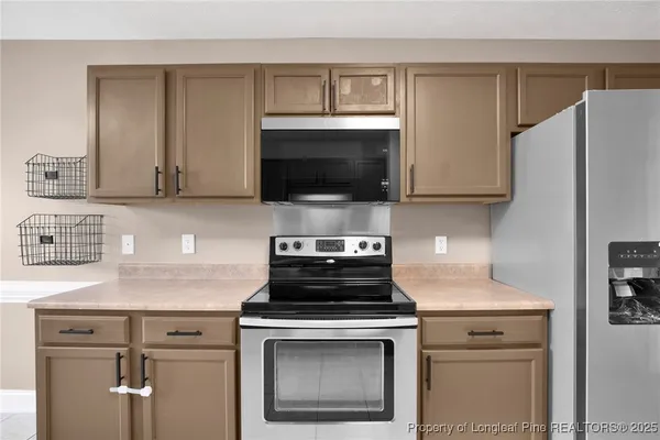 a kitchen with cabinets stainless steel appliances and a counter space