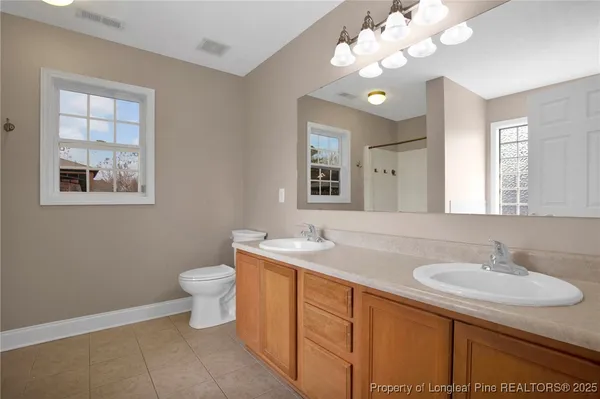 a bathroom with a sink vanity granite and toilet