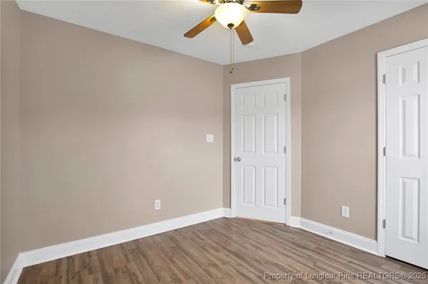 wooden floor in an empty room with a chandelier