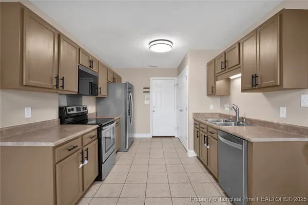 a kitchen with stainless steel appliances granite countertop a sink a stove and a refrigerator