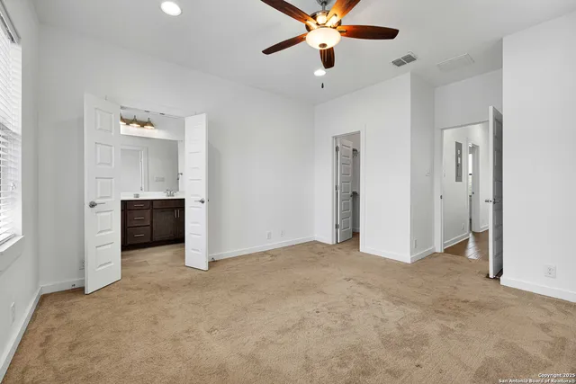 an empty room with windows and cabinet