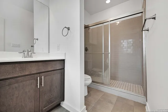 a bathroom with a shower sink vanity and toilet