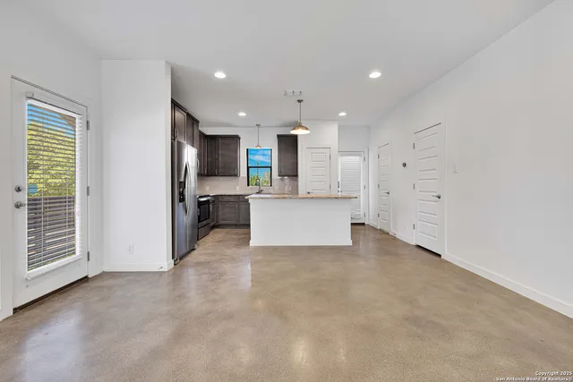a view of a kitchen with refrigerator and white cabinets