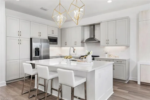 a kitchen with stainless steel appliances granite countertop a white cabinets and stove top oven