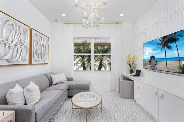 a living room with furniture a large window and a chandelier