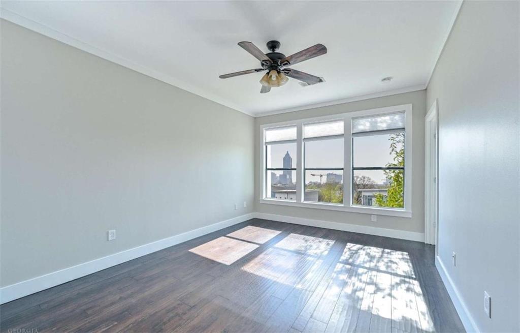 821 Ralph McGill Boulevard Northeast, Unit 2405 Atlanta, GA 30306 - Photo 11 of 12 an empty room with wooden floor fan and windows