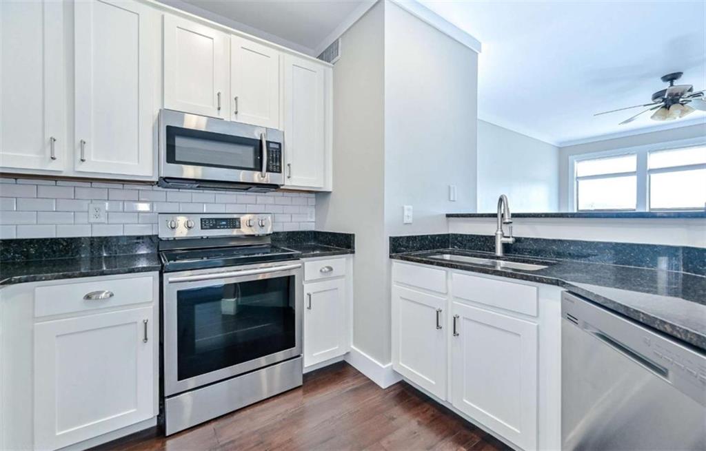 821 Ralph McGill Boulevard Northeast, Unit 2405 Atlanta, GA 30306 - Photo 2 of 12 a kitchen with granite countertop white cabinets stainless steel appliances and window