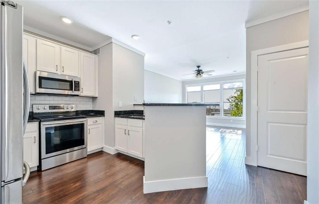 821 Ralph McGill Boulevard Northeast, Unit 2405 Atlanta, GA 30306 - Photo 6 of 12 a kitchen with a refrigerator stove and wooden floor