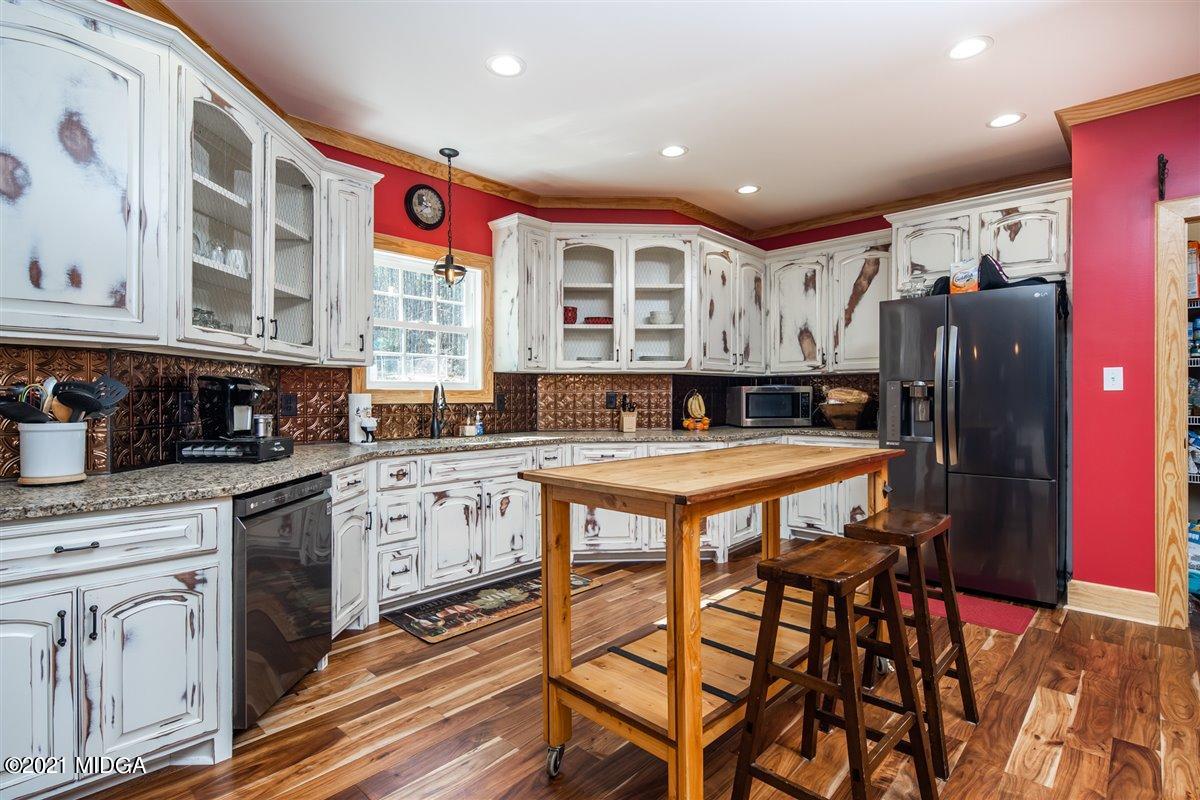 725 Taylor Road Juliette, GA 31046 - Photo 14 of 62 a kitchen with stainless steel appliances granite countertop a stove a sink dishwasher and cabinets with wooden floor