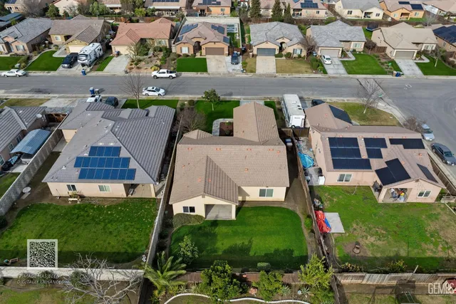 an empty room with chandelier fan and windows