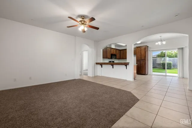 an empty room with closet and a chandelier fan