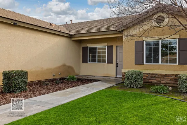 a living room with furniture a flat screen tv and kitchen view