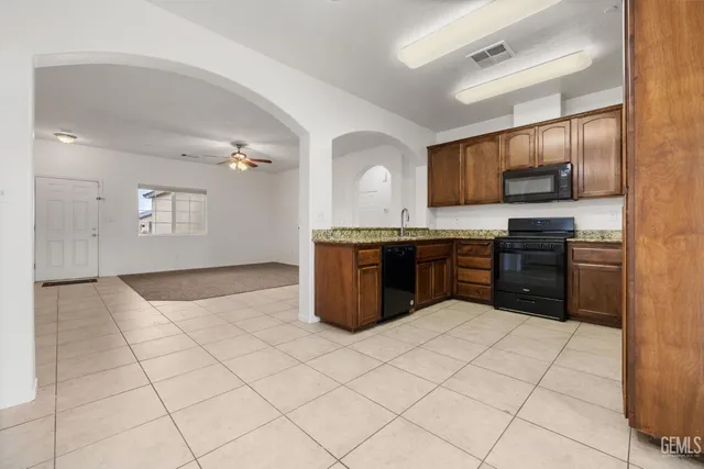 an empty room with a ceiling fan and carpet