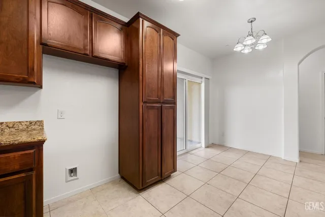 a view of an empty room and chandelier fan