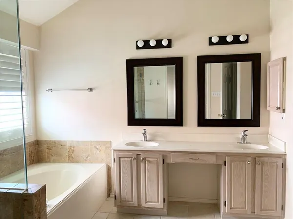 a bathroom with a tub sink and mirror