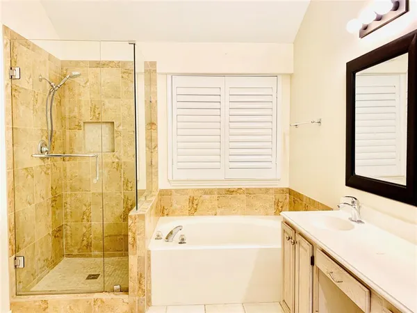 a bathroom with a granite countertop sink and a bathtub