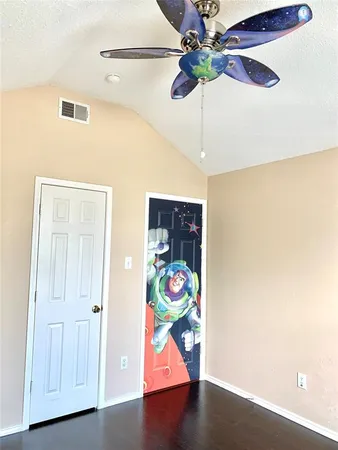 a room with wooden floor and ceiling fan