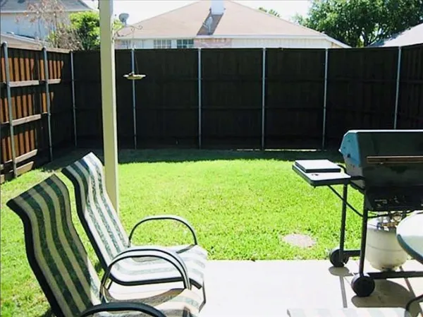 a backyard of a house with table chairs and a potted plant