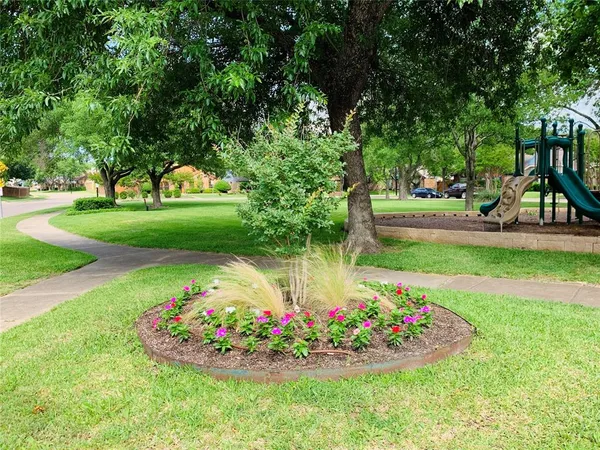 a view of a garden with flowers and trees