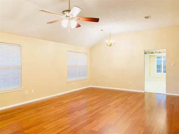 an empty room with a window and a ceiling fan