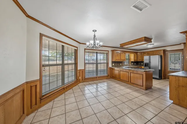 a view of an empty room with wooden floor and stairs