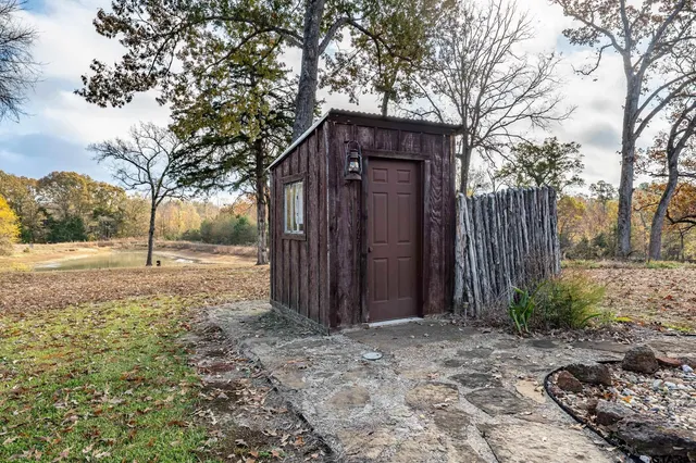a view of a lake with table and chairs next to a yard