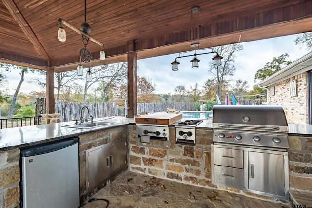 a view of a patio with table and chairs with wooden floor and fence