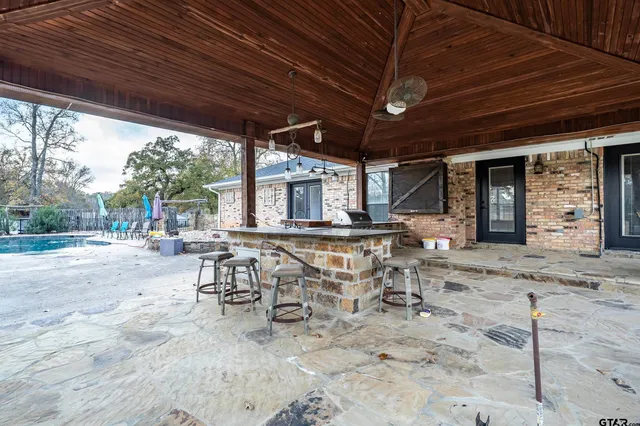 a view of a patio with a table and chairs under an umbrella