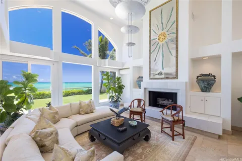 a living room with furniture a fireplace and potted plants