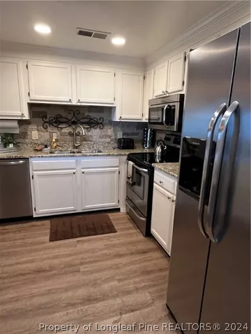 a kitchen with stainless steel appliances granite countertop a sink wooden cabinets and granite counter tops