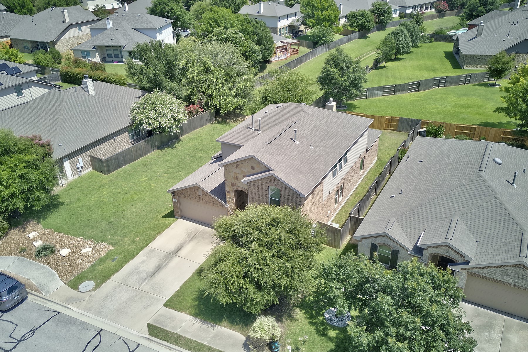 4601 Chestnut Meadows Bend Georgetown, TX 78626 - Photo 34 of 35 An aerial perspective reveals a contemporary residence with a paved driveway and an impeccably manicured lawn.