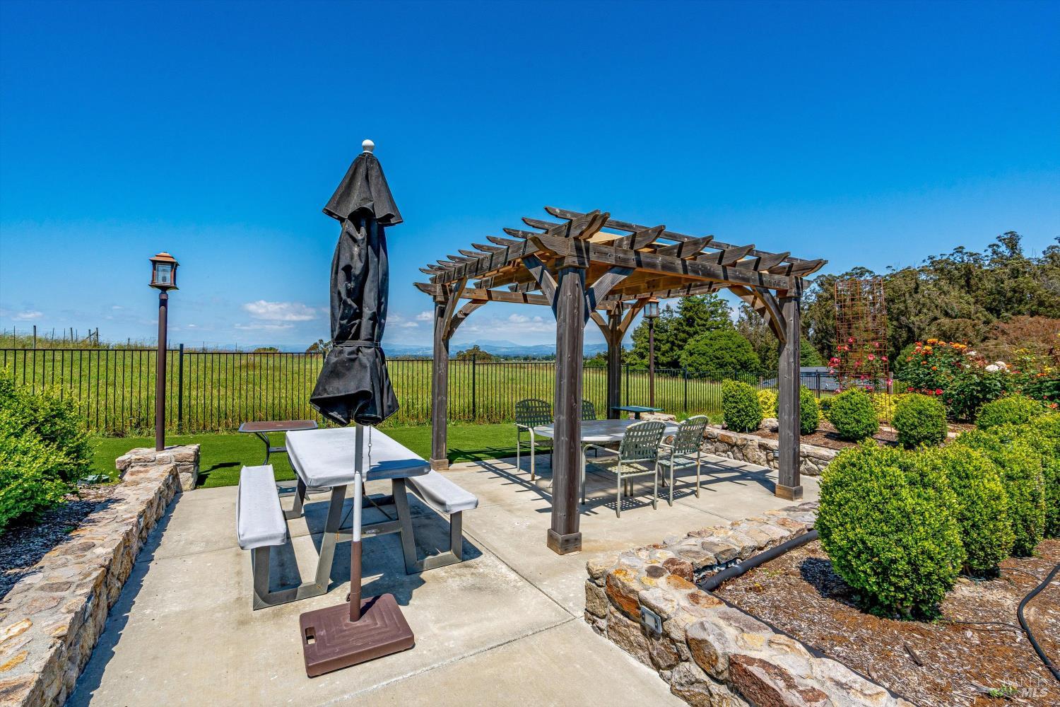 4760 Blank Road Sebastopol, CA 95472 - Photo 41 of 46 a view of a patio with a table and chairs under an umbrella with potted plants