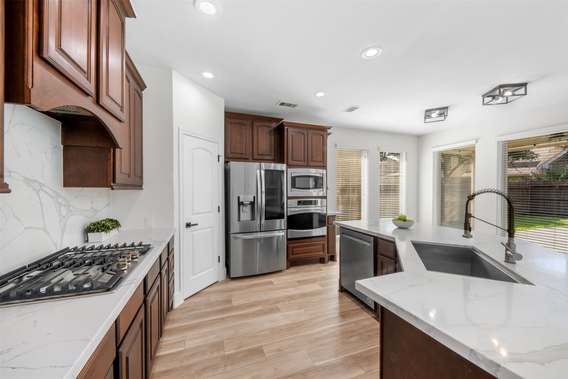 26422 Red Cliff Ridge Katy, TX 77494 - Photo 10 of 40 Medium brown wood-grain cabinets set off the beautiful, upgraded quartz counters and backsplash!