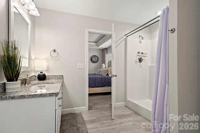 a bathroom with a granite countertop sink a mirror and shower