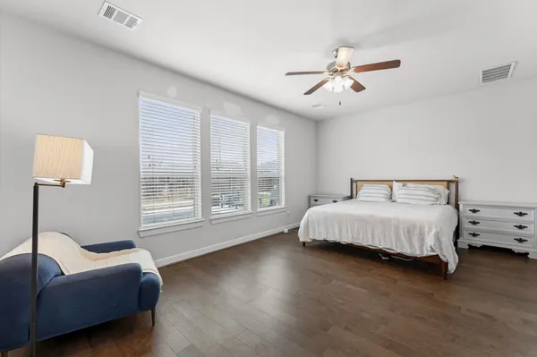 a spacious bedroom with a bed a couch and a window