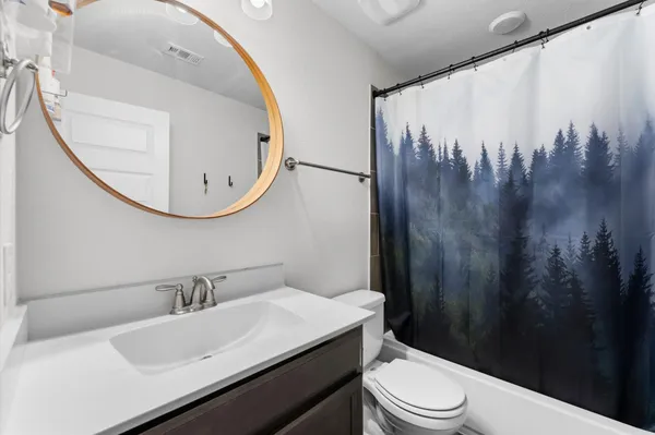 a bathroom with a sink a toilet and a mirror