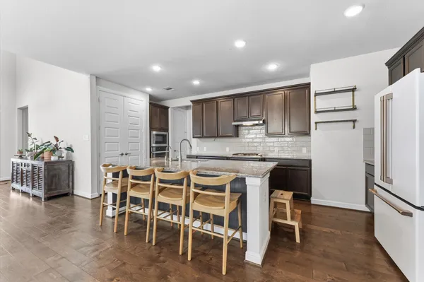 a kitchen with kitchen island granite countertop wooden cabinets and stainless steel appliances