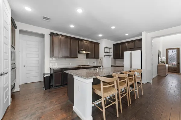 a kitchen with stainless steel appliances kitchen island granite countertop a refrigerator and microwave