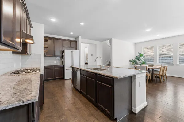 a kitchen with stainless steel appliances granite countertop a stove a sink a refrigerator and a refrigerator