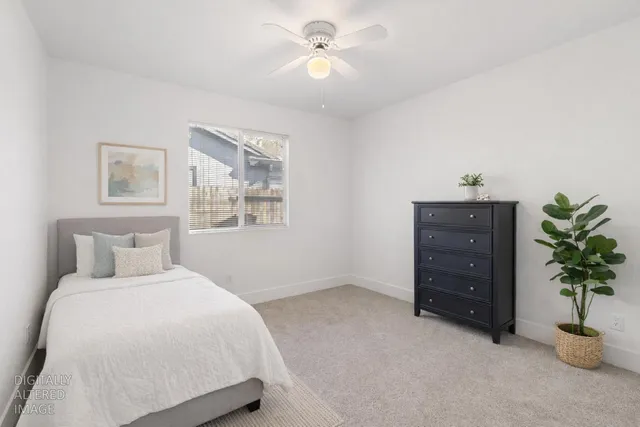 an empty room with a window and a ceiling fan