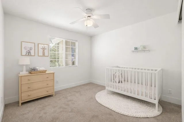 an empty room with windows and ceiling fan