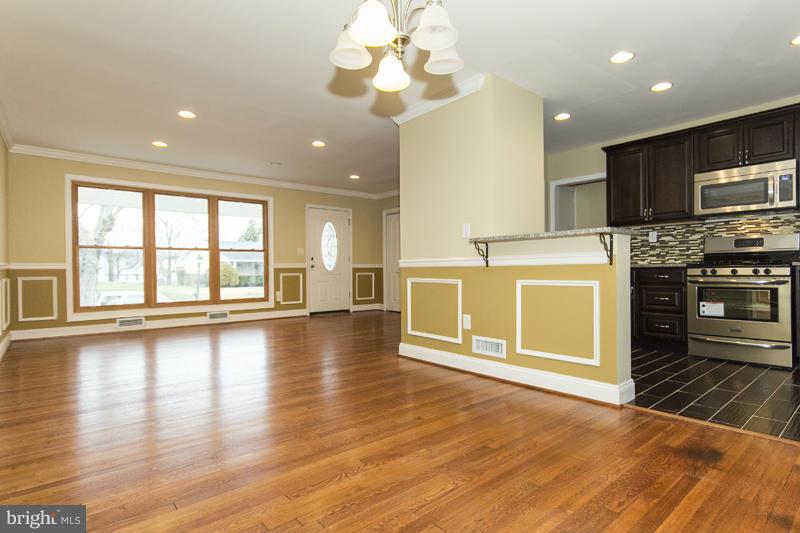 3405 Ripple Road Baltimore, MD 21244 - Photo 11 of 29 an empty room with wooden floor and kitchen view