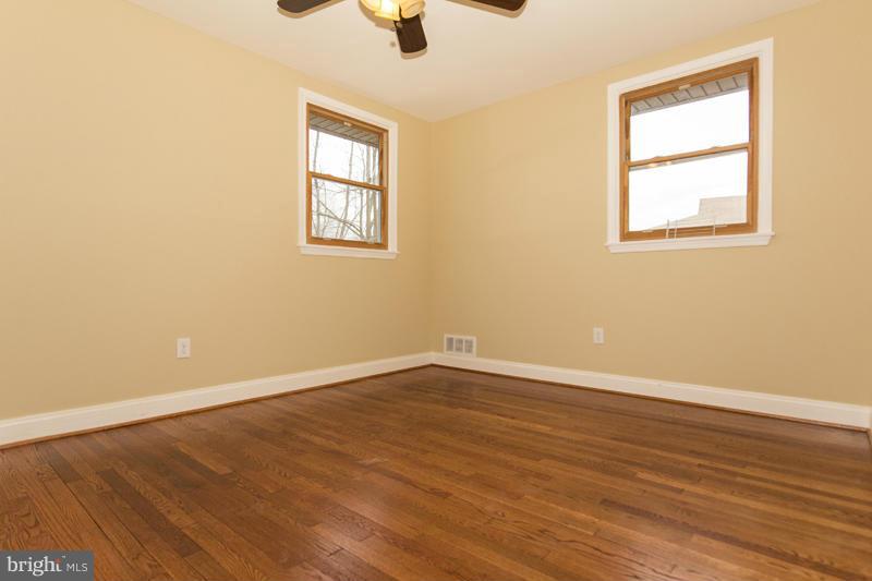 3405 Ripple Road Baltimore, MD 21244 - Photo 26 of 29 an empty room with wooden floor cabinet and windows